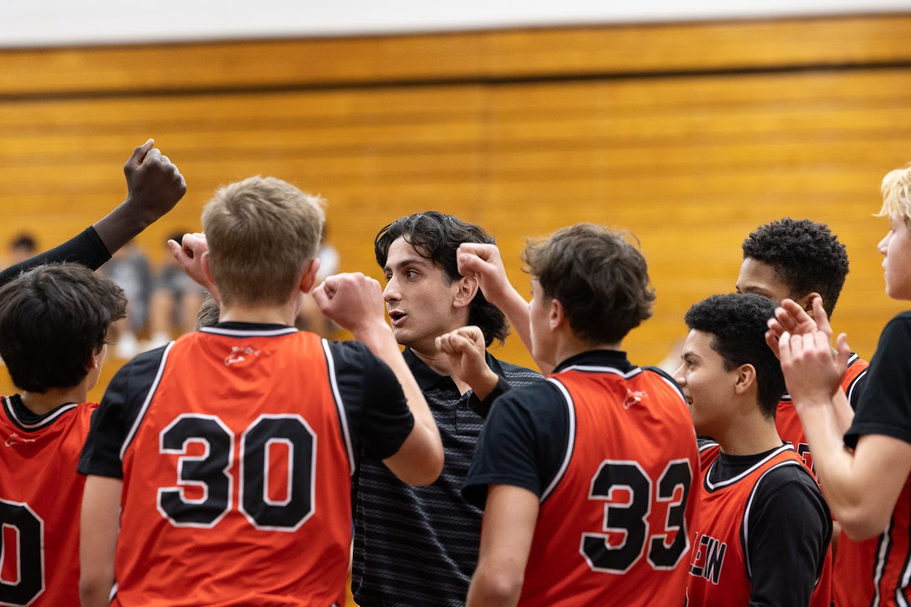 Coach Gio leading a team huddle